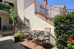stół i krzesła na patio obok schodów w obiekcie Apartment in Porec - Istrien 9922 w Poreču