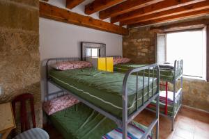 2 łóżka piętrowe w pokoju z oknem w obiekcie Hostal Rural La Pata de Oca y albergue solo por peregrinos w mieście Torres del Río