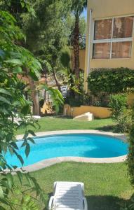 a pool with two lounge chairs and a house at Bungalow Puig Campana con barbacoa in Benidorm