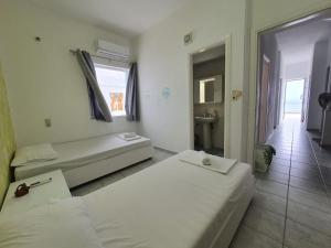 ein Hotelzimmer mit 2 Betten und einem Fenster in der Unterkunft Cozy Beach House South Crete in Paránimfoi