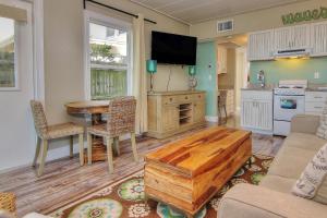 a living room with a table and a kitchen at Bungalow Beach Place 4 in Clearwater Beach