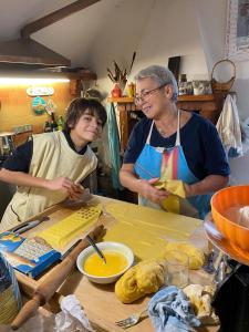 zwei Personen stehen in einer Küche und bereiten Essen zu in der Unterkunft Casa Curlo in Calvagese della Riviera
