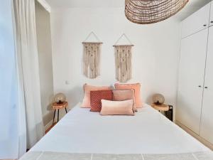 a bedroom with a white bed with pink pillows at Vila Rosário 3 studios with Patio by Homeful Homes in Lisbon