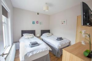 a room with two beds and a television in it at Helena Cottage in Elie