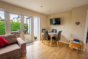 a living room with a couch and a table with chairs at Helena Cottage in Elie