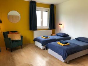 a room with two beds and a chair and a mirror at Bobr in Rozvadov
