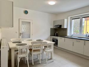 a white kitchen with a table and chairs in it at Bobr in Rozvadov