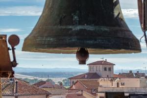 a large bell is hanging over a city at Camera Torre Panoramic in Montalto di Castro