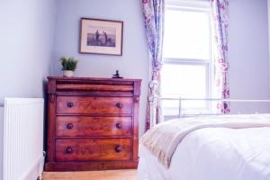 1 dormitorio con tocador de madera y cama en Stunning 3 bed house in the heart of Cheltenham, en Cheltenham