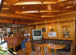 a woman standing in a living room with a television at Der Klaushof in Mayrhofen