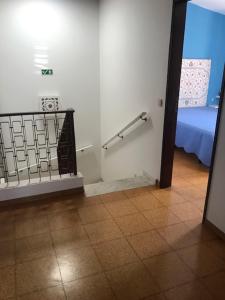 een kamer met een bed en een muur met een leuning bij Casa dos Pais in Odeceixe