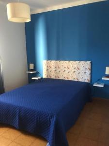 a blue bedroom with a bed with a blue wall at Casa dos Pais in Odeceixe