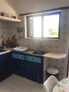 a kitchen with a sink and a window at Casa dos Pais in Odeceixe