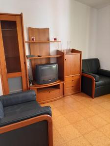 a living room with a tv and a couch and a chair at Casa dos Pais in Odeceixe