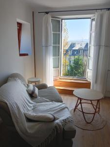 a bedroom with a bed and a large window at Escapade de charme les pieds dans l'eau in Houlgate
