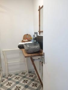 a bathroom with a table with a sink on a floor at Escapade de charme les pieds dans l'eau in Houlgate