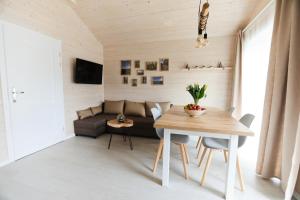 a living room with a table and a couch at Karuba Resort, Sobieszewo- Gdańsk - Wyspa Sobieszewska in Gdańsk