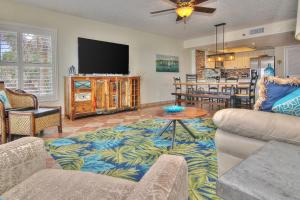 sala de estar con sofá y TV de pantalla plana en The Pointe 104 en Clearwater Beach