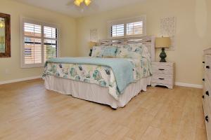 1 dormitorio con 1 cama y suelo de madera en The Pointe 104 en Clearwater Beach