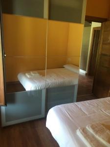 Zimmer mit 2 Betten und einem Spiegel in der Unterkunft El Llagar de Mon I in Llanes