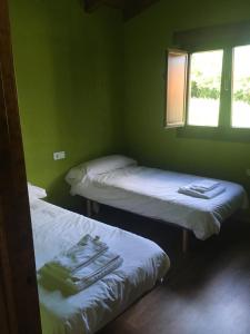 2 Betten in einem Zimmer mit grünen Wänden in der Unterkunft El Llagar de Mon I in Llanes