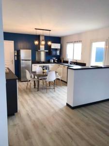 uma cozinha e sala de jantar com mesa e cadeiras em Maison de 3 chambres avec jacuzzi jardin clos et wifi a Breville sur Mer a 1 km de la plage em Bréville-sur-Mer
