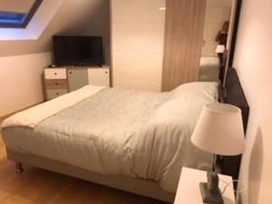 een slaapkamer met een bed en een tafel met een lamp bij Maison de 3 chambres avec jacuzzi jardin clos et wifi a Breville sur Mer a 1 km de la plage in Bréville-sur-Mer