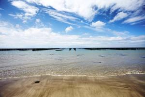 um corpo de água com uma praia e um céu nublado em Maison de 3 chambres avec jacuzzi jardin clos et wifi a Breville sur Mer a 1 km de la plage em Bréville-sur-Mer
