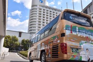 een dubbeldekkerbus geparkeerd voor een gebouw bij Kobe Portopia Hotel in Kobe