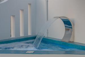una fuente de agua en una piscina en Vira Vivere Houses en Plaka Milou