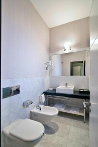 a white bathroom with a toilet and a sink at Alhambra Suites in Madrid