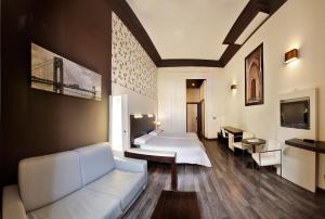 een hotelkamer met 2 bedden en een bank bij Alhambra Suites in Madrid