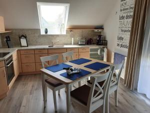 a kitchen with a table and chairs and a sink at Ferienwohnung Grujo in Blankenheim