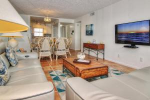 a living room with a couch and a flat screen tv at Landmark Towers 1606 in Clearwater Beach