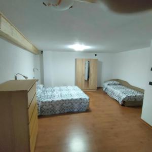 Una habitación con dos camas y un lavabo. en La Maison Lillà, en Fenis