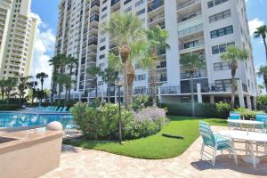 a resort with a pool and palm trees and a table and chairs at Landmark Towers 1606 in Clearwater Beach