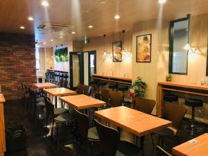 名古屋市にあるホテルリブマックス名古屋桜通口の木製のテーブルと椅子が備わるレストラン