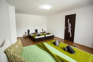 ein Schlafzimmer mit einem Bett mit einer grünen Decke in der Unterkunft Daddy House in Turda