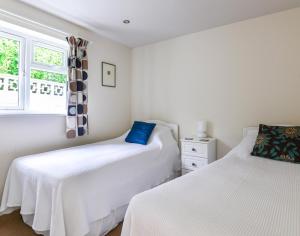 a bedroom with two beds and a window at Sea Mist in Polzeath
