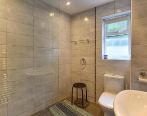 a bathroom with a toilet and a sink and a window at Sea Mist in Polzeath +10 photos