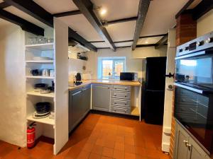 uma pequena cozinha com um frigorífico preto e um fogão em Hendy Cottage em Pwllheli