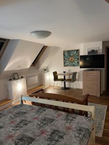 a bedroom with a bed and a table and a tv at KronSoul in Braşov