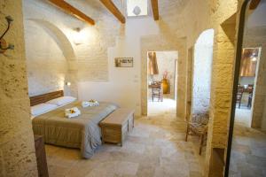 a bedroom with a large bed in a stone room at All'ombra dei lecci in Alberobello