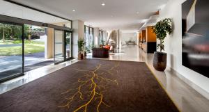 a hallway with a rug with a tree design on it at Sao Miguel Park Hotel in Ponta Delgada
