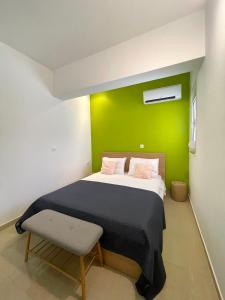 a bedroom with a bed with a green wall at Summer Breeze Villa in Afantou