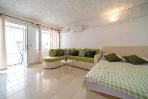 a bedroom with a bed and a couch in it at Guest House Ana in Petrovac na Moru