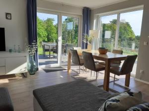 een woonkamer met een tafel en stoelen en een groot raam bij Forest View Apartments in Winterberg Sauerland in Medebach
