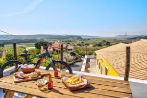 a picnic table with food and a bike on a balcony at Bedebike in Óbidos