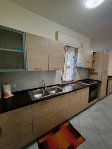 a kitchen with a sink and a stove at Appartamenti RoccaForte MONO BLU Trapani in Milo