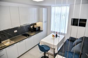 eine kleine Küche mit einem Tisch und einem blauen Stuhl in der Unterkunft Luxury Blue Bay Apartment in Opatija